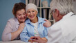 © nimito - Cancer patient woman visiting doctor with daughter and smiling hearing good news
