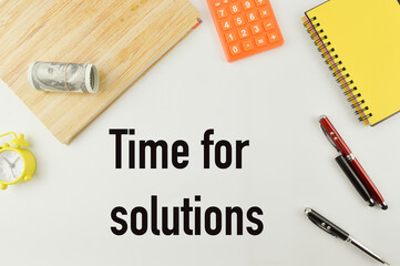 Selective focus of notebooks, pens, calculator, banknote and clock isolated on a white background written with text TIME FOR SOLUTIONS. Business and education concept.