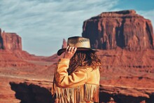 Side View Of Woman Wearing Hat Against Rock Formation And Sky