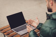 © deagreez - Close up cropped back photo of guy arms hands dressed green coat having rest sitting cafeteria typing modern gadget outdoors
