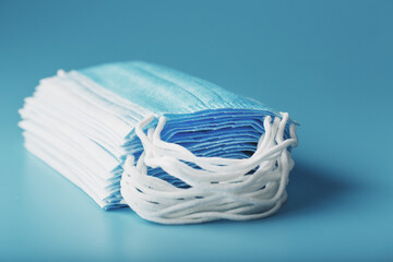 Wall Mural - Stack of protective medical masks on a blue background, isolate.