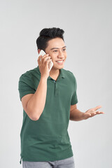 Wall Mural - Young handsome man talking on cellphone, excited, rejoicing, isolated on white background.