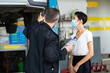 © NVB Stocker - Mechanic man and woman customer wearing medical face mask protection coronavirus and check the car condition before delivery.