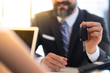 Sticker - Middle age business man with beard gives the car key to customer service at Car maintenance station and automobile service garage