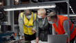 © TommyStockProject - Team of engineers in safety mask discussing blueprint at workplace at manufacturing plant