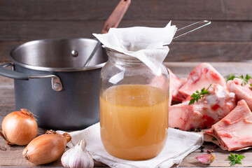 Passing the bone broth through a sieve and through a paper napkin. Concentrated Bone Broth in a Jar