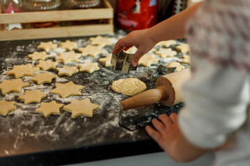 Wall Mural - little girl bakes cookies in the form of stars. Christmas cookies.