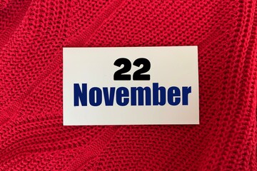 November 22 on a sticker on a red knitted background.Autumn .Calendar for November.