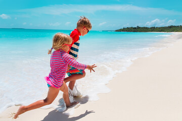 Poster - happy girl and boy run play with waves on beach