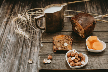 bread with dried fruits, milk, nuts, dried apricots on a wooden Board on top