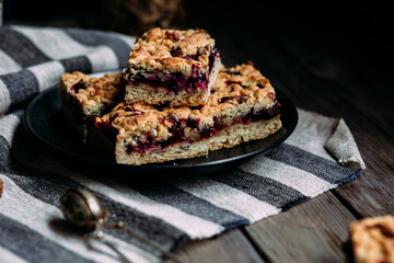 shortcrust pastry pie with black currants and tea on a dark background