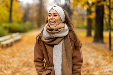 Wall Mural - portrait of smiling young woman in a park in autumn