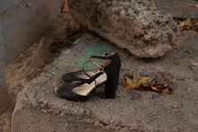 Black Women's Sandals Shoes That No One Needs Stand Near A Trash Can On The Street In Autumn.