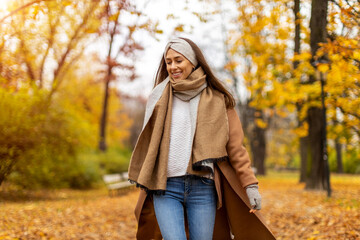 Wall Mural - portrait of smiling young woman in a park in autumn