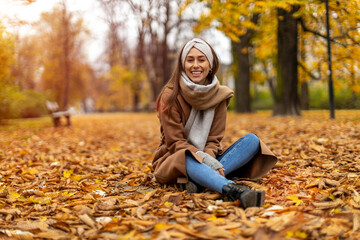 Wall Mural - portrait of smiling young woman in a park in autumn