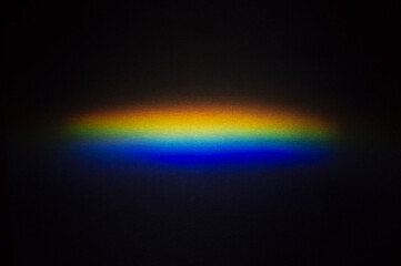 A spot of decomposed light on a dark background. Light spectrum.