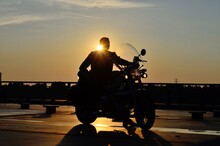 Silhouette Man Sitting On Motorcycle Against Sky During Sunset