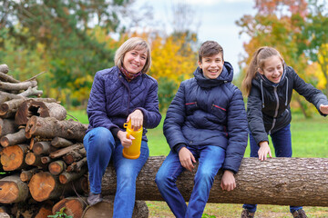 Wall Mural - family relaxing outdoor in autumn city park, happy people together, parents and children, they talking and smiling, beautiful nature