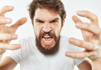 A young man in a white T-shirt gestures with his hands emotions irritability stress