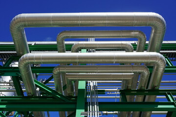 Wall Mural - Insulated pipes installed on the steel structure in the power plant and have a sky background.