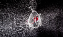 Close-up Of Bursting Water Bomb Against Black Background