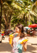 Happy woman in drinking mango shake on vacation, Thailand.