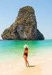 Woman in swimsuit and hat on the beach, Krabi, Thailand.
