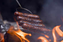 High Angle View Of Sausages In Skewer Over Fire On Barbecue Grill