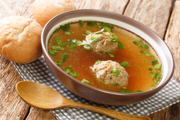 clear beef broth with liver dumplings close up in a dish on the table. horizontal