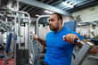 © Rowena Naylor Photography/Stocksy - Heavy set man lifting weights at a gym