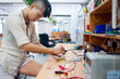 © Carlo Amoruso/Stocksy - Young adult woman in workshop working on design of printed circuit board.