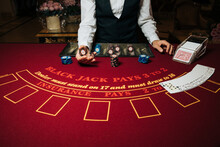Croupier Hands Dealing Cards On T Blackjack Poker Table, Gambling Table With Cards And Chips