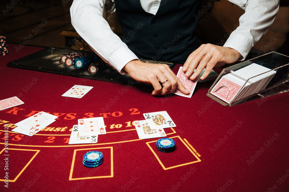 Croupier hands dealing cards on t blackjack poker table, gambling table with cards and chips - obrazy, fototapety, plakaty 