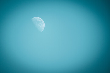 A full white moon on a clear blue sky.