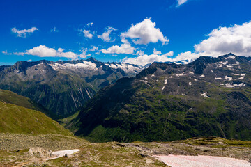 Wall Mural - Landscape mountain view peaks in snow and green hills, deep blue sky and huge white clouds background, Hohe Tauern Austrian Alps, Europe