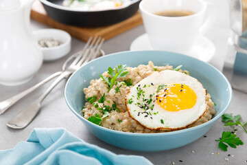 Poster - Savoury oatmeal with fried eggs sunny side up for breakfast