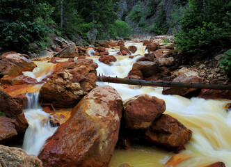 Long Time Exposure Of The Flowing Water Of A Creek At Million Dollar Highway Colorado On A Sunny Summer Day