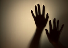 Silhouette Hands Touching Glass Window