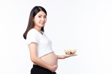 Happy pregnant young asian mother with fruits healthy food for baby and pregnant woman on white background with copy space. Healthy Food Concept.