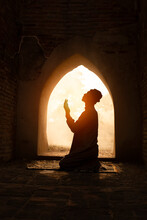 Silhouette Religious Of Muslim Male Praying In Old Mosque With Lighting And Smoke Background