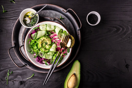 vegan, detox buddha bowl with watermelon radish, avocado, lettuce, microgreen, cabbage, cucumber. to