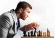 © adam121 - Businessman moving chess figure in chessboard