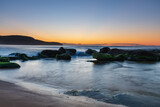 Fototapeta Krajobraz - Sunrise by the Sea and Rocks on the Shoreline