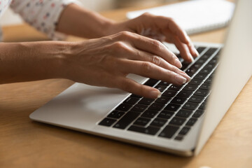 Poster - Crop close up of woman hands typing texting on laptop keyboard. Female employee or worker use computer, write compose email consult business client online. Girl study distant on gadget from home.