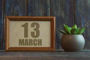 Wall Mural - march 13th. Day 13 of month, date in frame next to succulent on wooden background spring month, day of the year concept