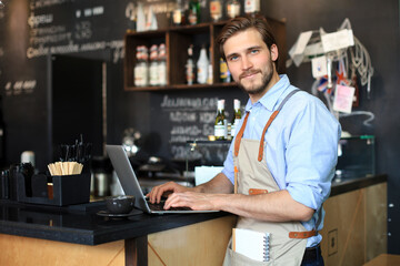 Wall Mural - Restaurant manager working on laptop, counting profit.