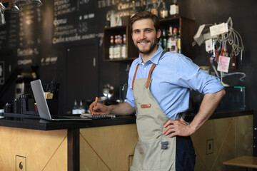 Wall Mural - Small business owner working at his cafe.