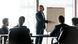 © fizkes - Wide banner panorama view of businessman present company financial business project on whiteboard. Male coach or trainer make flip chart presentation for businesspeople at meeting in office.