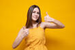 Young beautiful caucasian woman in a yellow t-shirt on an isolated yellow background showing a thumb up