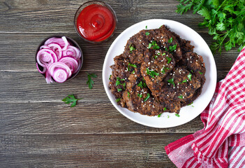 Wall Mural - Fried liver pieces with tomato sauce, pickled onions and cucumbers. Delicious healthy dish. Top view.